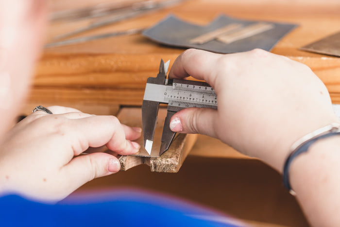 An image of a person measuring an item with a calliper