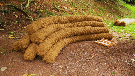 HEIGER brown coir logs stacked outdoors on soil near grassy area for erosion control