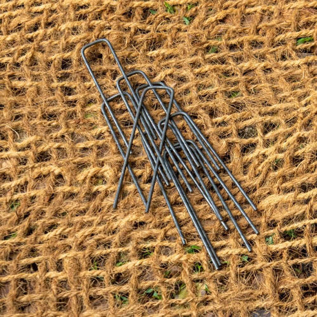 HEIGER metal weed mat pins securing brown woven landscaping fabric to ground