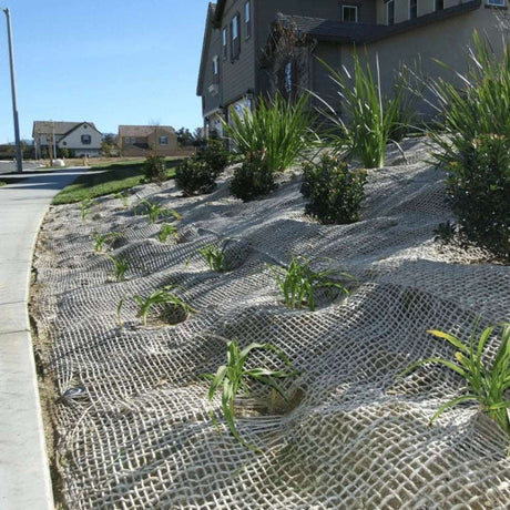 HEIGER jute mesh covering a landscaped slope with plants to prevent soil erosion near residential area
